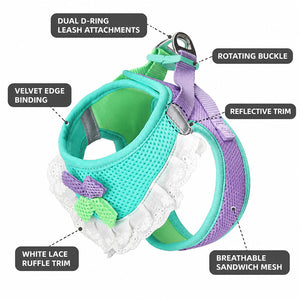 Mint and lavender mesh dog harness detail showing dual D-ring attachments, a rotating buckle, reflective trim, fabric edge binding, and white lace ruffles.